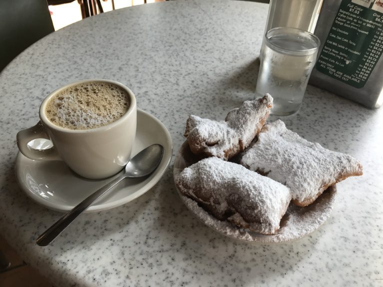 Beignets can coffee on a table 