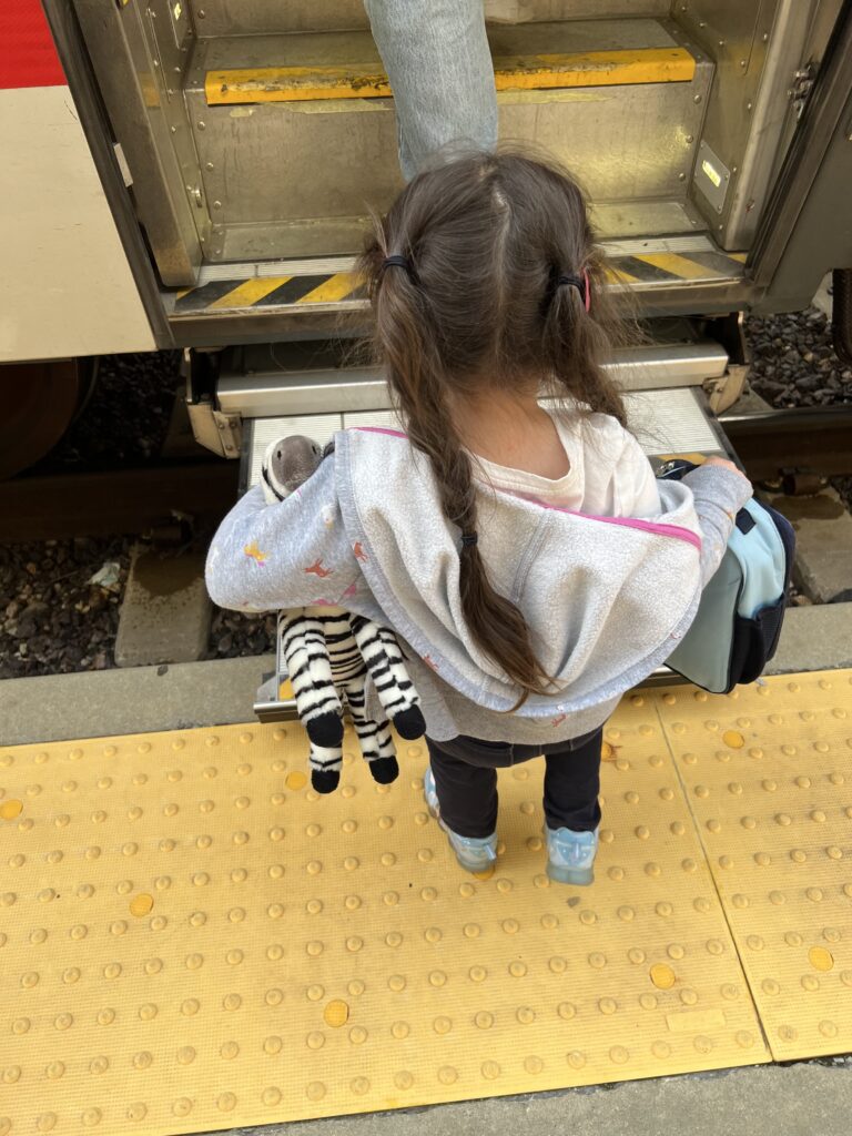 Mackenzie and Zebra getting in her Amtrak coach car