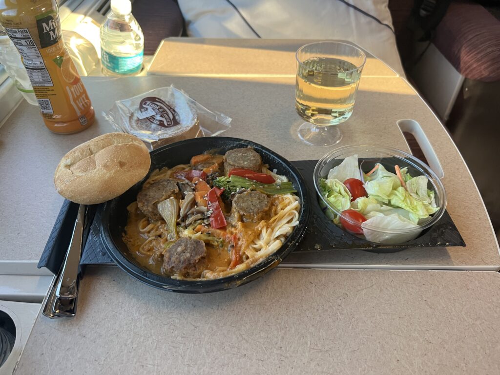 My Amtrak Flex Dining severed in My Amtrak Viewliner Roomette: Thai Red Curry Street Noodles, with dessert and white wine.
