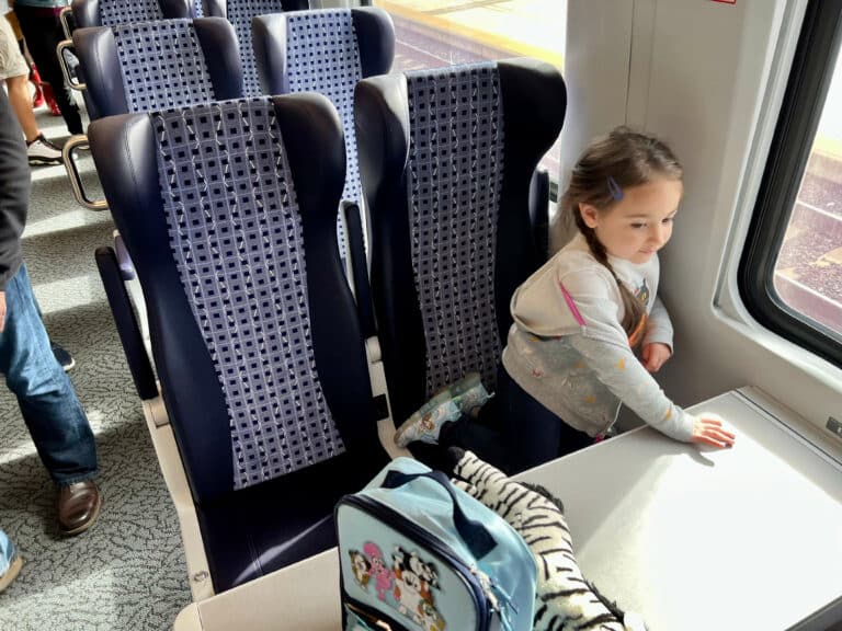 My niece sitting at a table in the new Amtrak Venture cars